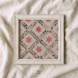 May include: A framed vintage quilt print with a white distressed wooden frame. The quilt features a repeating pattern of pink stars and patchwork triangles in various colors. The text "dandy vintage prints" is in the bottom right corner.