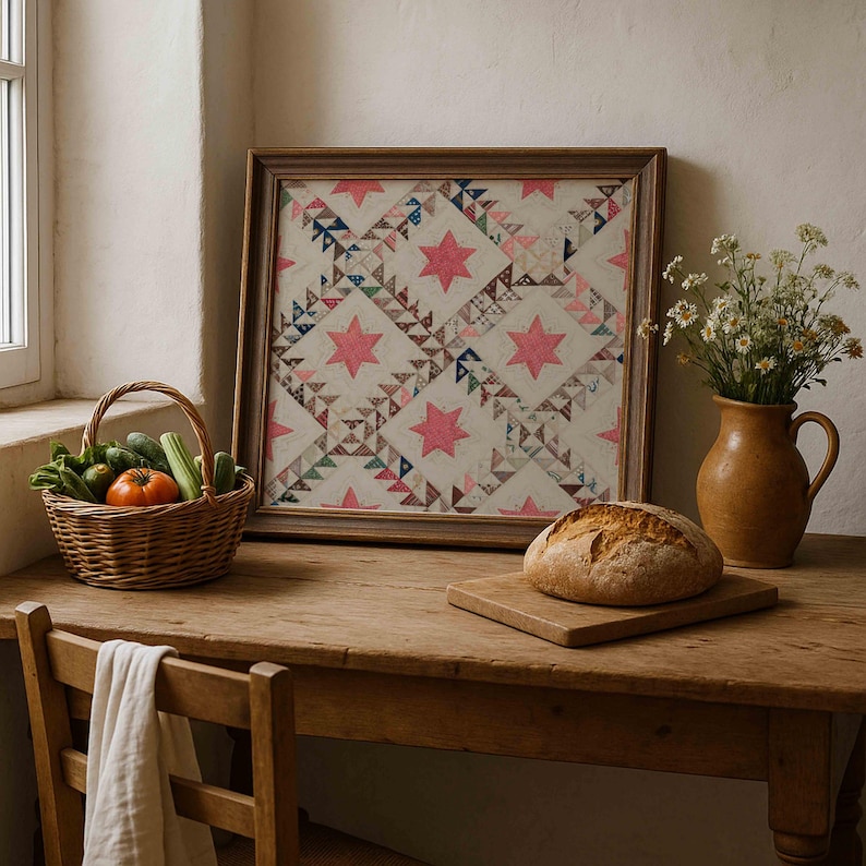 May include: A framed quilt with a star pattern in pink and cream tones sits on a wooden table. A basket of vegetables, a loaf of bread, and a vase of flowers complete the rustic scene. The table is made of wood.