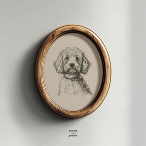 Peut inclure: Une impression ovale encadrée de bois, représentant un croquis à la plume et à l'encre d'un chien. Le chien a un pelage touffu et porte une écharpe. L'impression est sur fond neutre. Les mots "dandy vintage prints" sont en bas.