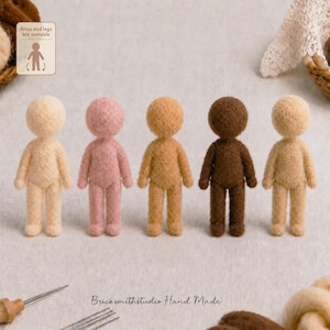 May include: Five needle-felted wool dolls in varying skin tones, including cream, light pink, tan, dark brown, and beige. Each doll features a round head, simple torso, and limbs. A small sign in the corner reads: Arms and legs are movable.