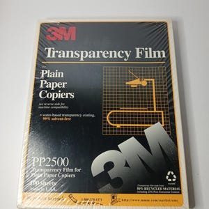 May include: A rectangular package of 3M Transparency Film for plain paper copiers. The black and orange packaging features the 3M logo, a grid graphic with an overhead projector illustration, and text including PP2500, 100 sheets, and 50% recycled material.