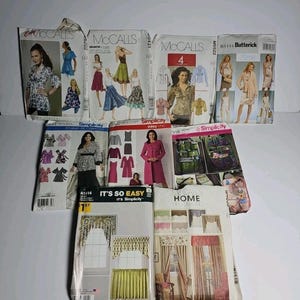 Könnte beinhalten: Eine Sammlung von neun Schnittmusterumschlägen der Marken McCall's, Butterick und Simplicity. Die Umschläge zeigen Illustrationen und Fotografien verschiedener Kleidungsstücke wie Blusen, Kleider und Jacken sowie Vorhänge für die Heimdekoration.