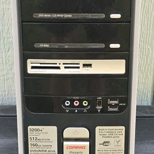 以下が含まれることがあります： 黒と銀色のCompaq Presario SR1230NXデスクトップコンピュータタワー。フロントパネルには、DVD/CDライターコンボドライブ、CD-ROMドライブ、マルチフォーマットメモリカードリーダー、USB 2.0ポート、オーディオジャック、FireWireポートが搭載されています。