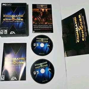 May include: Command & Conquer The First Decade PC DVD game set including a black plastic case, two game discs with blue and black graphics, a printed manual, and a promotional insert. All items feature the gold and black game logo and EA branding.