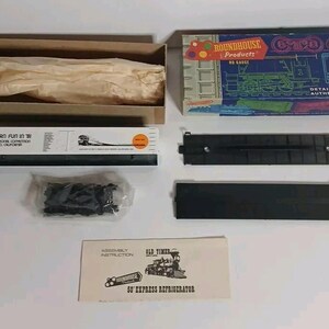 May include: A Roundhouse Products HO gauge model train kit in a blue box with white text. Includes a cardboard box, a plastic train car frame, a black plastic base, a small bag of black plastic parts, and an assembly instruction sheet for a 50' express refrigerator car.