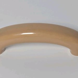 May include: A smooth, arched cabinet handle with a glossy, light beige finish. The hardware features a curved, semi-circular design with rounded ends, providing a simple and functional grip for furniture or cabinetry doors and drawers.