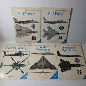 Può includere: Una collezione di cinque libri con copertina flessibile della serie Osprey Combat Aircraft con illustrazioni aeronautiche e titoli tra cui F-14 Tomcat, F-15 Eagle, AH-64 Apache, Stealth Warplanes e American Spyplanes con varie immagini di aerei militari.