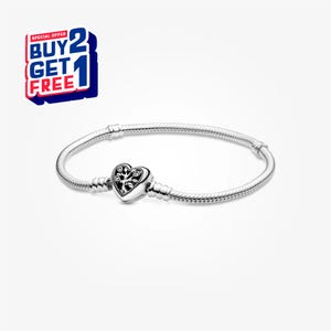 May include: A silver bracelet with a heart-shaped charm. The charm features a tree design. The bracelet has a snake chain design. The image also includes a "Buy 2 Get 1 Free" promotional offer.
