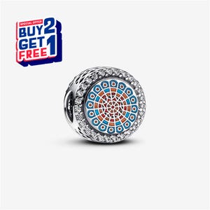 Könnte beinhalten: Ein silberner Charm mit einem farbenfrohen kreisförmigen Design mit blauen, orangefarbenen und weißen Akzenten. Der Charm ist von einem Ring aus klaren Steinen umgeben. Das Bild enthält auch ein Werbeangebot "KAUFE 2 BEKOMME 1 GRATIS".