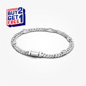Puede incluir: Una pulsera plateada con un diseño de eslabones y detalles en forma de corazón. La pulsera tiene un cierre con el nombre de la marca "Pandora". La imagen también incluye una oferta promocional "Compra 2 y llévate 1 gratis".
