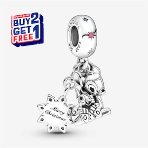 May include: A silver charm with a Bambi design, a snowflake with "Merry Christmas" text, and a charm with the word "Pandora" and star accents. The charm is a holiday-themed jewelry item.