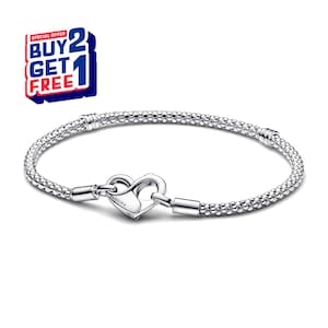 Op de afbeelding: Een zilveren armband met een hartvormige sluiting. De armband is gemaakt van kleine, onderling verbonden kralen. De sluiting is gegraveerd met de merknaam "Pandora". De afbeelding bevat ook een promotieaanbieding "Koop 2 krijg 1 gratis".