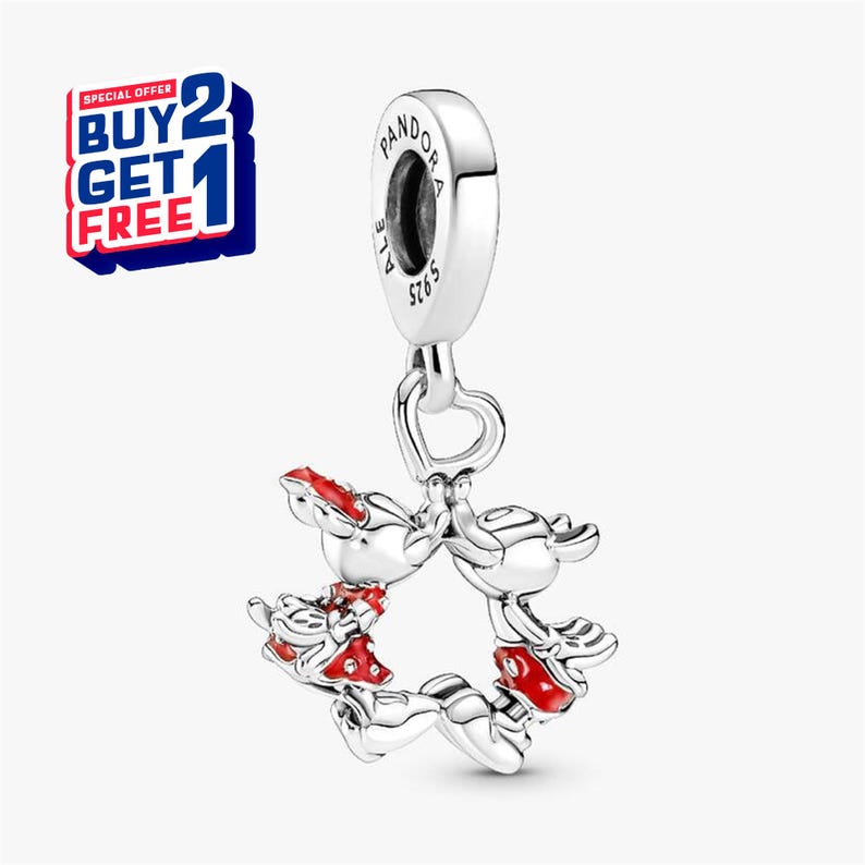 Puede incluir: Un charm de plata con un broche en forma de coraz&oacute;n, que presenta un dise&ntilde;o en forma de estrella de figuras de Mickey Mouse con detalles en rojo. El charm est&aacute; marcado con "Pandora" y "S925 ALE". Se ve una oferta de "Compra 2 y ll&eacute;vate 1 gratis".