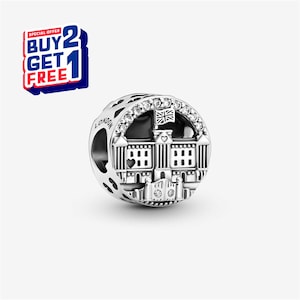 May include: A silver charm featuring a detailed depiction of Buckingham Palace, with a Union Jack flag and sparkling accents. The charm has the word "LONDON" engraved on the side. A "BUY 2 GET 1 FREE" offer is displayed in the upper left corner.