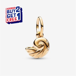 Puede incluir: Un charm dorado con forma de concha de nautilus, con pequeños detalles brillantes. El charm tiene un lazo para sujetarlo a una pulsera o collar. El texto "PANDORA" es visible en la concha. Una oferta "COMPRA 2 Y LLÉVATE 1 GRATIS" es visible.