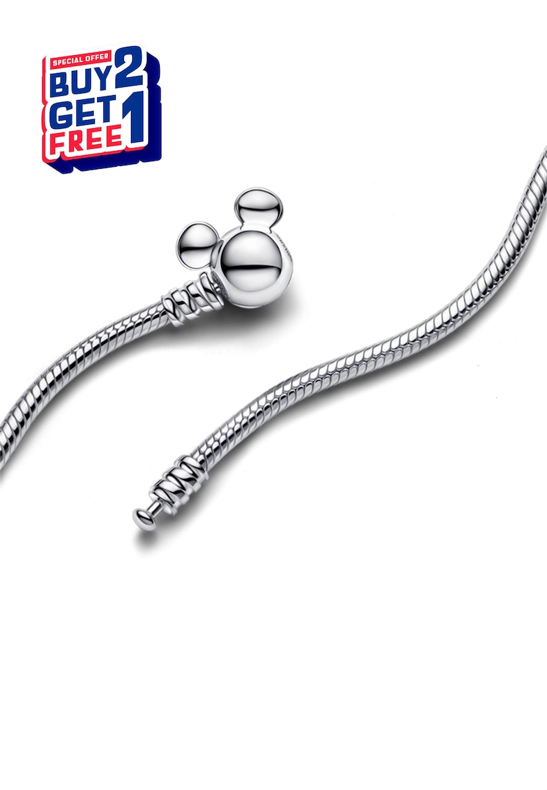 K&ouml;nnte beinhalten: Ein silbernes Armband mit einem Mickey-Mouse-f&ouml;rmigen Verschluss. Das Armband hat ein Schlangenketten-Design. Das Bild enth&auml;lt auch eine rot-wei&szlig;-blaue Grafik mit der Aufschrift "BUY 2 GET 1 FREE".