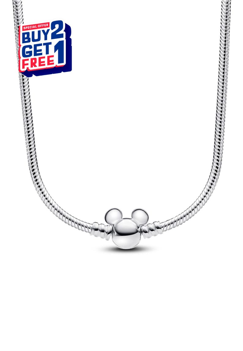 K&ouml;nnte beinhalten: Eine silberfarbene Halskette mit einem Mickey Mouse-Anh&auml;nger. Die Halskette hat ein Schlangenketten-Design und einen runden Anh&auml;nger mit zwei kleinen Kreisen oben und einem gr&ouml;&szlig;eren Kreis darunter. Das Bild enth&auml;lt auch ein "KAUFE 2 BEKOMME 1 GRATIS"-Angebot.