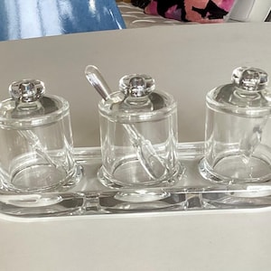 May include: A set of three ceramic mugs with a speckled, matte finish. The mugs are in shades of cream, light gray, and dark gray. Each mug has a simple, minimalist design, perfect for coffee or tea.