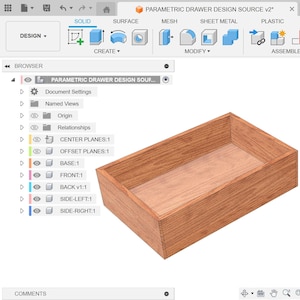 Peut inclure: Rendu 3D d'un tiroir en bois. Le tiroir est rectangulaire avec une finition marron clair. L'image est une capture d'écran d'un logiciel de conception, avec le titre "PARAMETRIC DRAWER DESIGN SOURCE v2*" visible en haut.