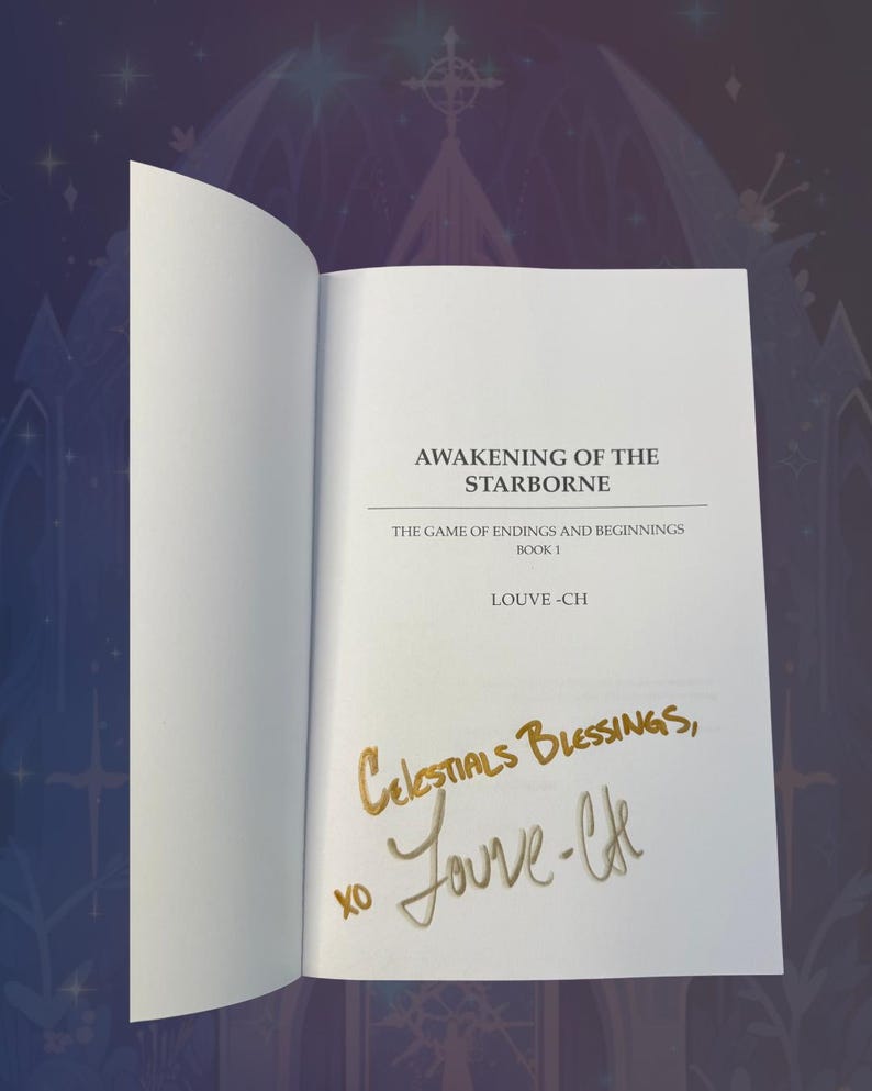 May include: An open book with the title "AWAKENING OF THE STARBORNE" and the author's name "LOUVE-CH" printed on the page. The book is signed with gold ink, reading "Celestial Blessings, xo Jouve-lfe."