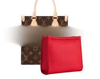 May include: A brown handbag with a repeating logo pattern, a small matching wallet, and a bright red insert. The handbag has a light tan handle and trim. The wallet and handbag feature the same logo pattern.
