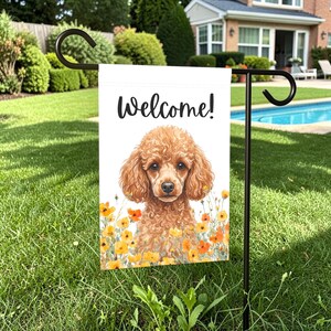 May include: A garden flag with the word "Welcome!" in black script. The flag features a watercolor illustration of a brown poodle surrounded by yellow and orange flowers. The flag is displayed on a black metal stand in a grassy yard.