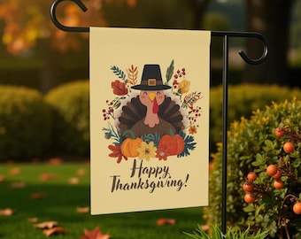 May include: A Thanksgiving garden flag featuring a cartoon turkey wearing a pilgrim hat, surrounded by pumpkins and fall foliage. The flag has the words "Happy Thanksgiving!" printed on it. The flag is displayed on a black metal stand.