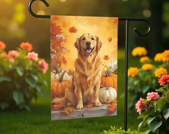 Pode incluir: Uma bandeira de jardim com um cão Golden Retriever sentado entre abóboras e folhas de outono. O cão tem uma expressão feliz. O fundo é de uma cor dourada quente, com folhas caindo. A bandeira é exibida em um suporte de metal preto.