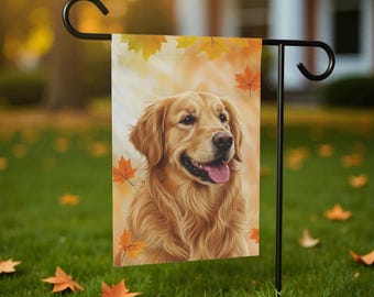 Pode incluir: Uma bandeira de jardim com um cão Golden Retriever com uma expressão feliz, rodeado por folhas de outono. A bandeira é exibida em um suporte de metal preto, em um fundo desfocado de grama verde e árvores.