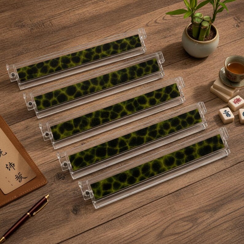 May include: Five rectangular clear acrylic display stands arranged in a diagonal row. Each stand features a long, narrow insert with a dark green and black mottled, organic pattern resembling a cell structure or animal print texture.
