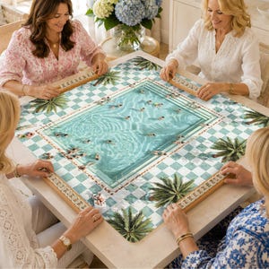May include: A square game board featuring a swimming pool illustration with turquoise water, swimmers, and palm trees, surrounded by a white and green checkered border. Four wooden tile racks are positioned at the edges of the board.