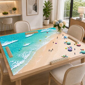 May include: A rectangular dining table featuring a large, high-resolution printed tabletop graphic of a sunny beach scene with turquoise ocean waves, sandy shores, miniature figures of people, colorful beach umbrellas, and four wooden tile racks.