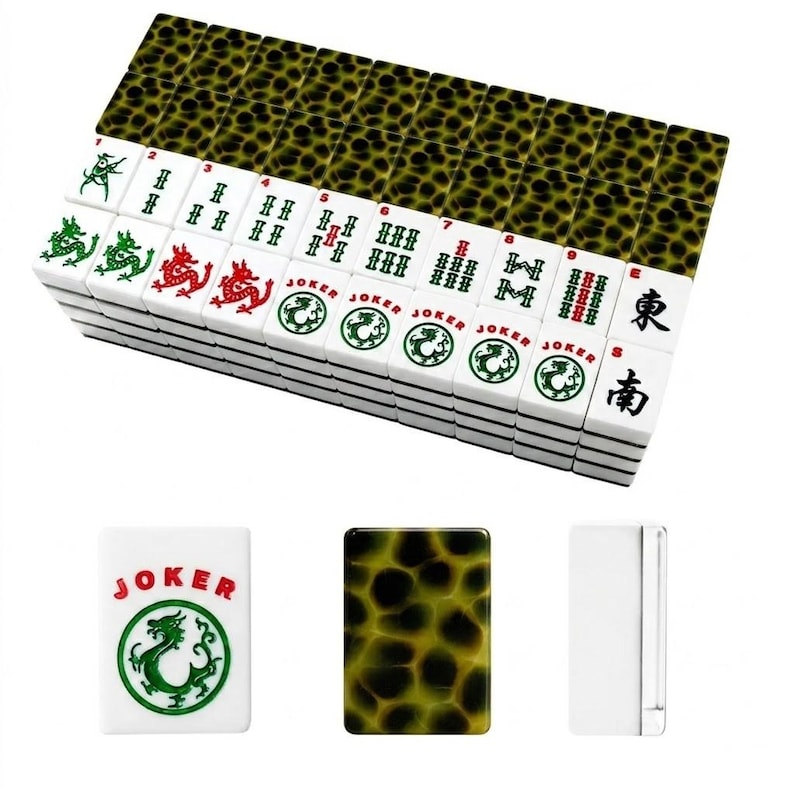 May include: A set of rectangular mahjong tiles featuring a white face with green, red, and black characters, including dragon symbols, numbers, and the word JOKER. The reverse side of each tile displays a dark green and black tortoiseshell pattern.