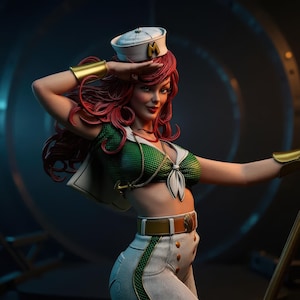 Puede incluir: Estatua de una mujer con un atuendo de temática marinera. Lleva un gorro de marinero blanco con una "M" dorada, una parte superior verde y blanca y pantalones blancos con botones dorados. Su pelo rojo está peinado en ondas y lleva brazaletes dorados.