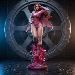 May include: A collectible figurine of a superhero character with long red hair, wearing a pink and maroon bodysuit with a cape and matching boots. The figure stands on a base featuring a translucent pink crystalline structure and metallic atom symbols.