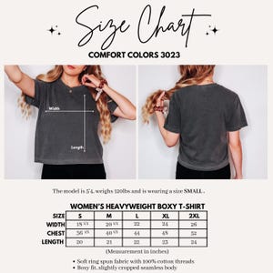 Peut inclure: Un tableau des tailles pour un t-shirt boxy &eacute;pais Comfort Colors 3023. L'image montre des vues avant et arri&egrave;re d'un t-shirt gris anthracite avec des indicateurs de largeur et de longueur, un tableau des tailles en pouces et des d&eacute;tails.