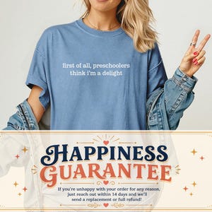 May include: A blue short-sleeved t-shirt featuring the white text "first of all, preschoolers think i'm a delight" printed on the chest. The shirt has a crew neckline and a relaxed fit, worn layered under a blue denim jacket.