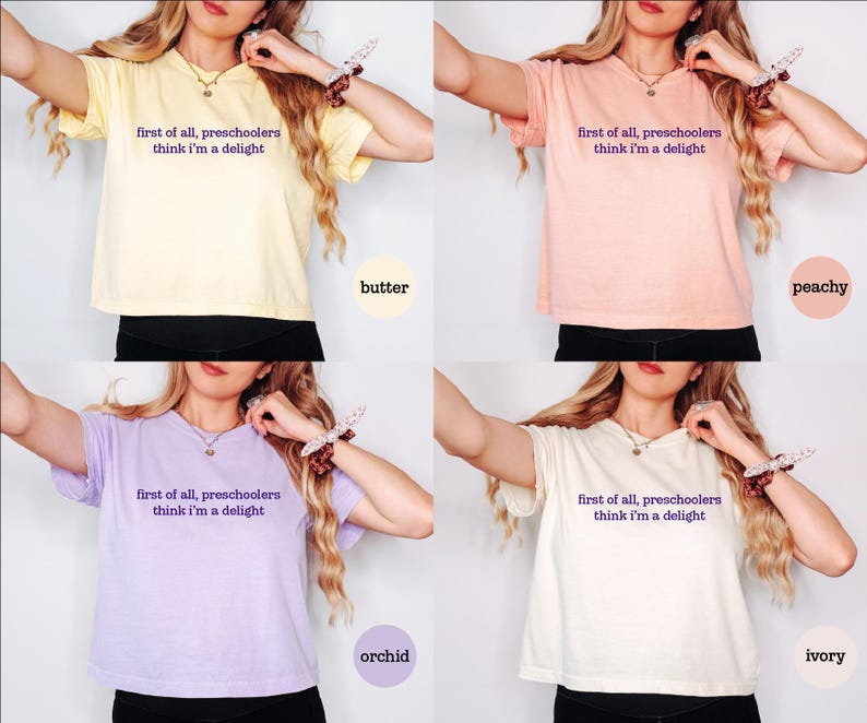 May include: A collection of four short-sleeved t-shirts in butter yellow, peachy orange, orchid purple, and ivory white. Each shirt features the dark purple text "first of all, preschoolers think i'm a delight" printed across the centre of the chest.