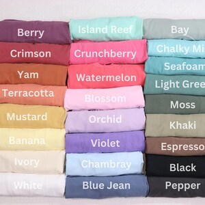 Peut inclure: Une collection de t-shirts pli&eacute;s dispos&eacute;s en grille, chacun &eacute;tiquet&eacute; avec son nom de couleur : Berry, Crimson, Yam, Terracotta, Mustard, Banana, Ivory, White, Island Reef, Crunchberry, Watermelon, Blossom, Orchid, Violet, Chambray, Blue Jean, Bay, Chalky Mint, Seafoam, Light Green, Moss, Khaki, Espresso, Black et Pepper.