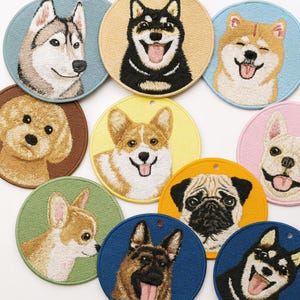 May include: Embroidered round patches featuring various dog breeds, including a Husky, Shiba Inu, Corgi, and Pug. Each patch has a different colored background, such as blue, yellow, and green, and showcases detailed facial expressions.