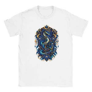 Könnte beinhalten: Ein weißes kurzärmeliges T-Shirt mit einer zentralen Grafik einer gewundenen blauen Schlange, die mit goldenem Schmuck und Mondsichel-Akzenten verziert ist, umgeben von dunkelblauen Lotusblüten und goldenen Filigran-Elementen auf der Brust.