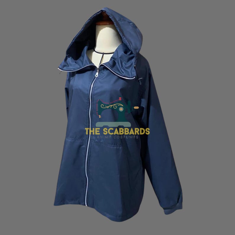 Op de afbeelding: Een marineblauwe jas met capuchon, volledige ritssluiting en witte bies. De jas heeft een hoge kraag en een capuchon met trekkoord. De tekst "THE SCABBARDS ANIME COSTUMES" staat op de voorkant.