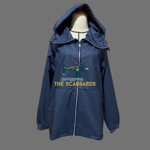 Op de afbeelding: Marineblauwe jas met capuchon en een ritssluiting over de hele lengte. De jas heeft een capuchon met trekkoord en elastische manchetten. De tekst "THE SCABBARDS" is op de voorkant gedrukt. De jas wordt op een mannequin gepresenteerd.