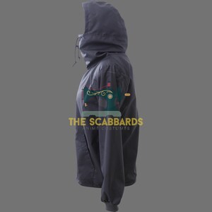 Op de afbeelding: Een donkergrijze jas met capuchon, hoge kraag en trekkoord. De jas heeft een ritssluiting en een klein zakje op de borst. De tekst "THE SCABBARDS ANIME COSTUMES" staat op de mouw.