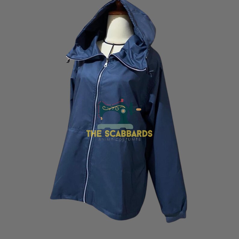 Op de afbeelding: Een marineblauwe jas met capuchon, een ritssluiting over de hele lengte, witte bies en een hoge kraag. De jas heeft lange mouwen en een capuchon. De tekst "THE SCABBARDS" staat op de voorkant. De jas wordt op een mannequin getoond.