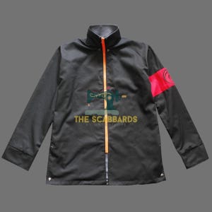 May include: A black long-sleeve jacket featuring a high collar and a bright orange vertical zipper closure. The left sleeve displays a prominent red horizontal band with a circular black emblem. The jacket has a structured fit with cuffs.