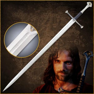 Op de afbeelding: Een zilveren zwaard met een zwarte handgreep en pareerstang, met gegraveerde tekst langs het lemmet. Het zwaard wordt gepresenteerd tegen een kaartachtergrond, met een close-up van de inscriptie van het lemmet. Het zwaard is een rekwisiet uit een fantasyfilm.