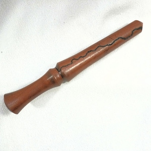 May include: A brown wooden wand with a dark, wavy line design. The wand has a handle and a tapered end. The wand is approximately 12 inches long.