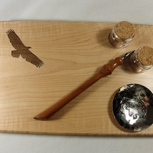 May include: A wooden tray with a carved eagle design, two glass inkwells with cork stoppers, a metal dish with a carved buffalo design, and a wooden calligraphy pen.