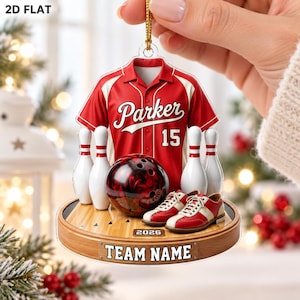 May include: A flat, hanging ornament featuring a red and white bowling shirt with the name Parker and number 15, a bowling ball, two bowling pins, and a pair of bowling shoes on a wooden lane base labeled 2026 and TEAM NAME.